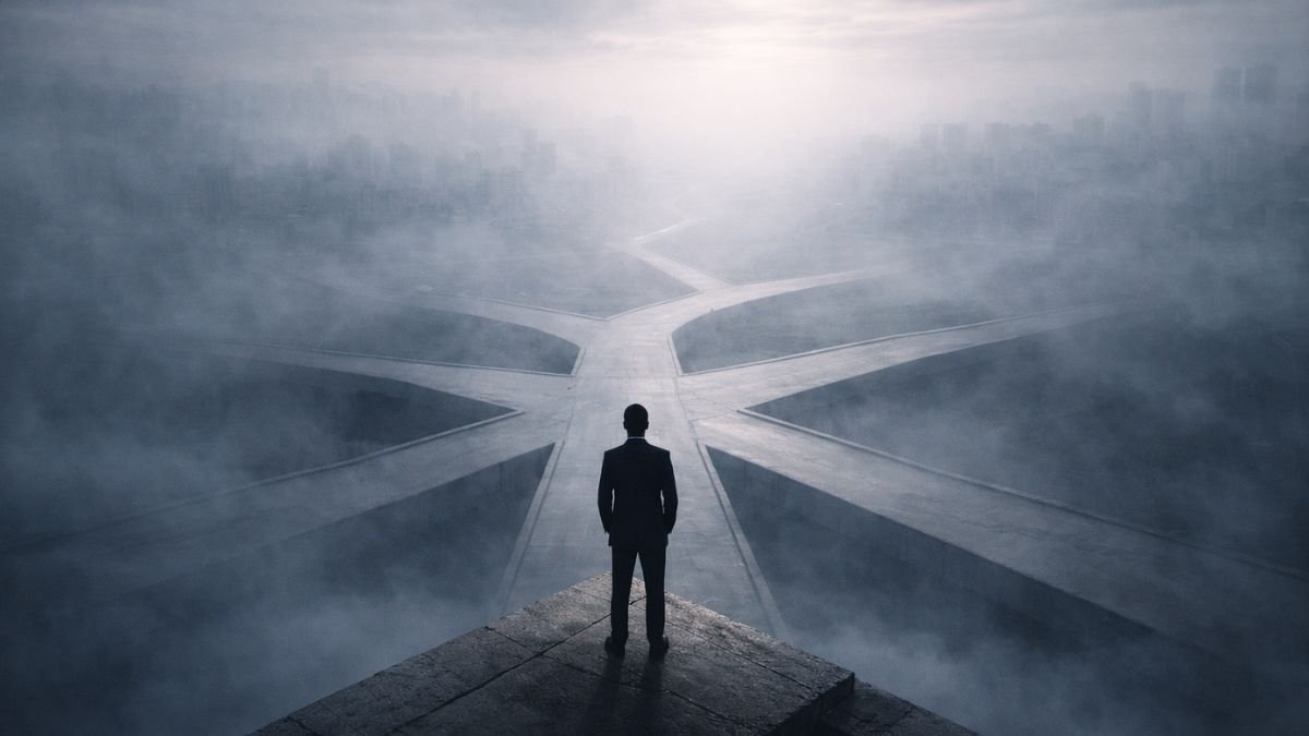 Decisão Estratégica Sob Incerteza É O Que Separa Quem Constrói De Quem Reage 1 Figura solitária diante de múltiplos caminhos parcialmente ocultos por neblina, simbolizando decisão sob incerteza