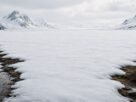 Paisagem coberta por neve começando a derreter discretamente nas extremidades enquanto o centro permanece aparentemente intacto.