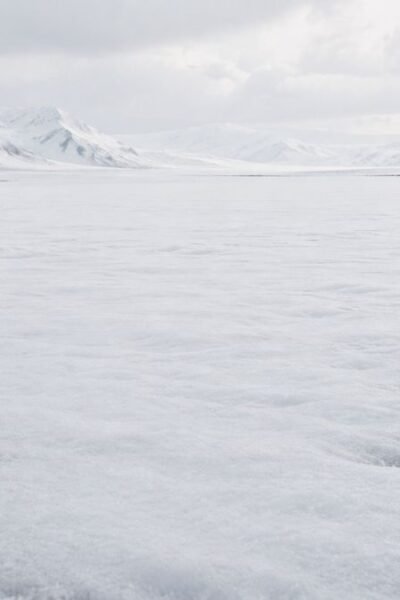 Paisagem coberta por neve começando a derreter discretamente nas extremidades enquanto o centro permanece aparentemente intacto.